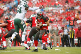 TAMPA, FL - NOVEMBER 12:  Quarterback Ryan Fitzpatrick #14 of the Tampa Bay Buccaneers evades defensive end Kony Ealy #94 of the New York Jets during the first quarter of an NFL football game on November 12, 2017 at Raymond James Stadium in Tampa, Florida. (Photo by Brian Blanco/Getty Images)