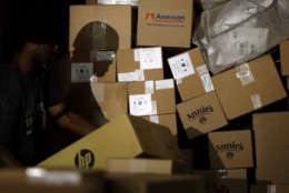 In this Nov. 20, 2015 photo, a worker's shadow is cast against boxes as he unloads them from a truck trailer at Worldport in Louisville, Ky. UPS and FedEx have been working with major retailers to hone their forecasts and have tailored their extra holiday workers to better meet the shipping spikes right after Thanksgiving and the weekend before Christmas. (AP Photo/Patrick Semansky)