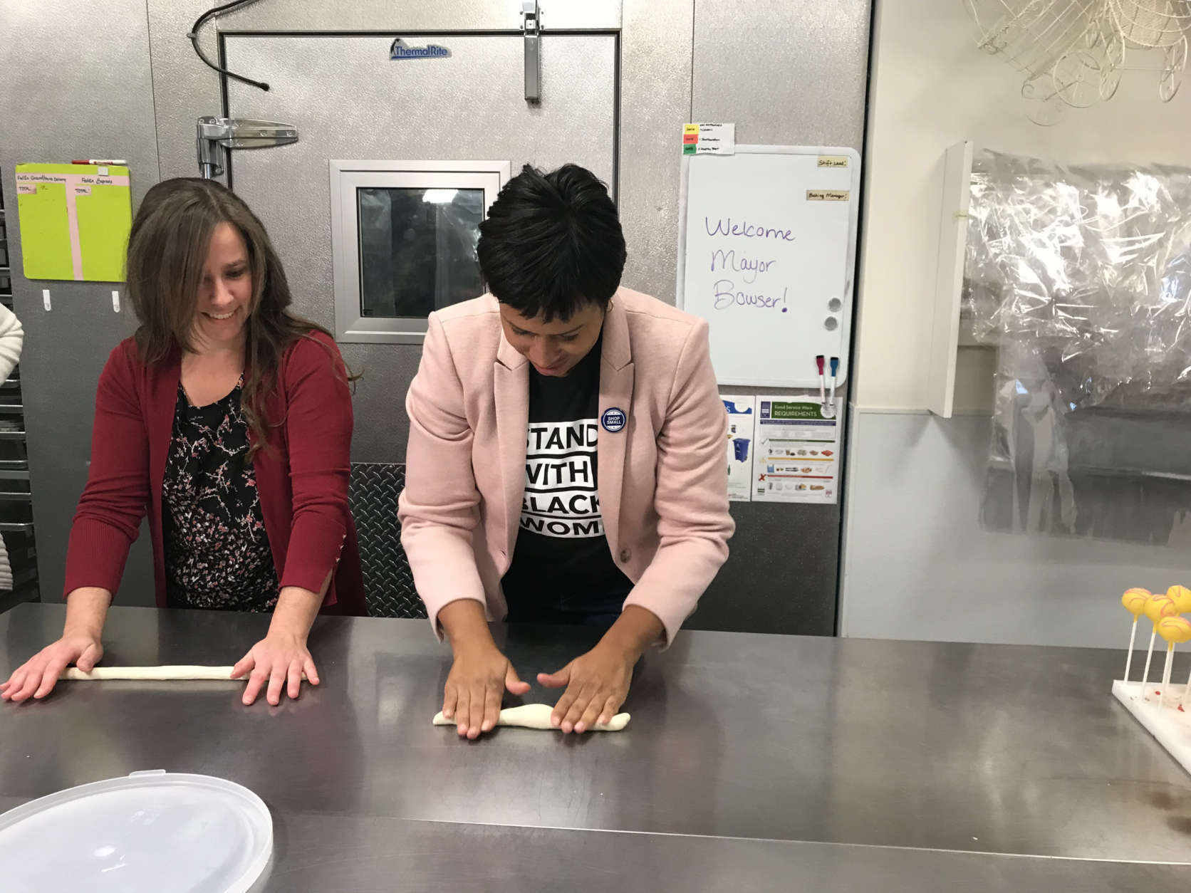 "We want to remind people all up and down Connecticut Avenue that she sells great bagels and cake pops." Mayor Bowser said after trying her hand at rolling bagels and dipping cake pops in chocolate covering. (WTOP/Dick Uliano) 
