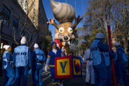 Participants stand below a parade balloon before the Macy's Thanksgiving Day Parade begins in New York, Thursday, Nov. 23, 2017. (AP Photo/Craig Ruttle)