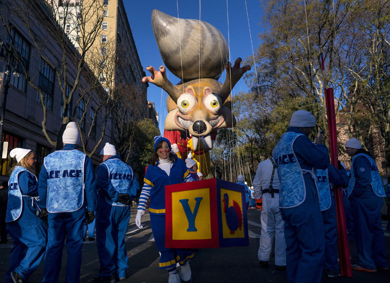 Participants stand below a parade balloon before the Macy's Thanksgiving Day Parade begins in New York, Thursday, Nov. 23, 2017. (AP Photo/Craig Ruttle)