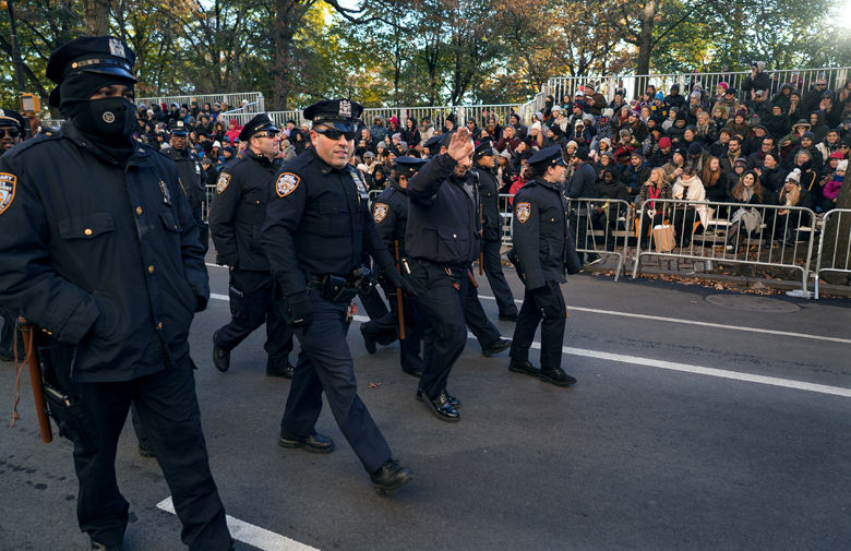 New York Police Department officers are greeted by people before the start of the Macy's Thanksgiving Day Parade in New York, Thursday, Nov. 23, 2017. (AP Photo/Craig Ruttle)