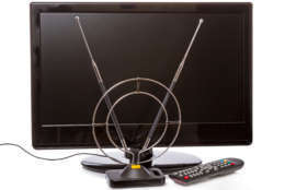 TV with remote control and indoor antenna isolated on a white background
