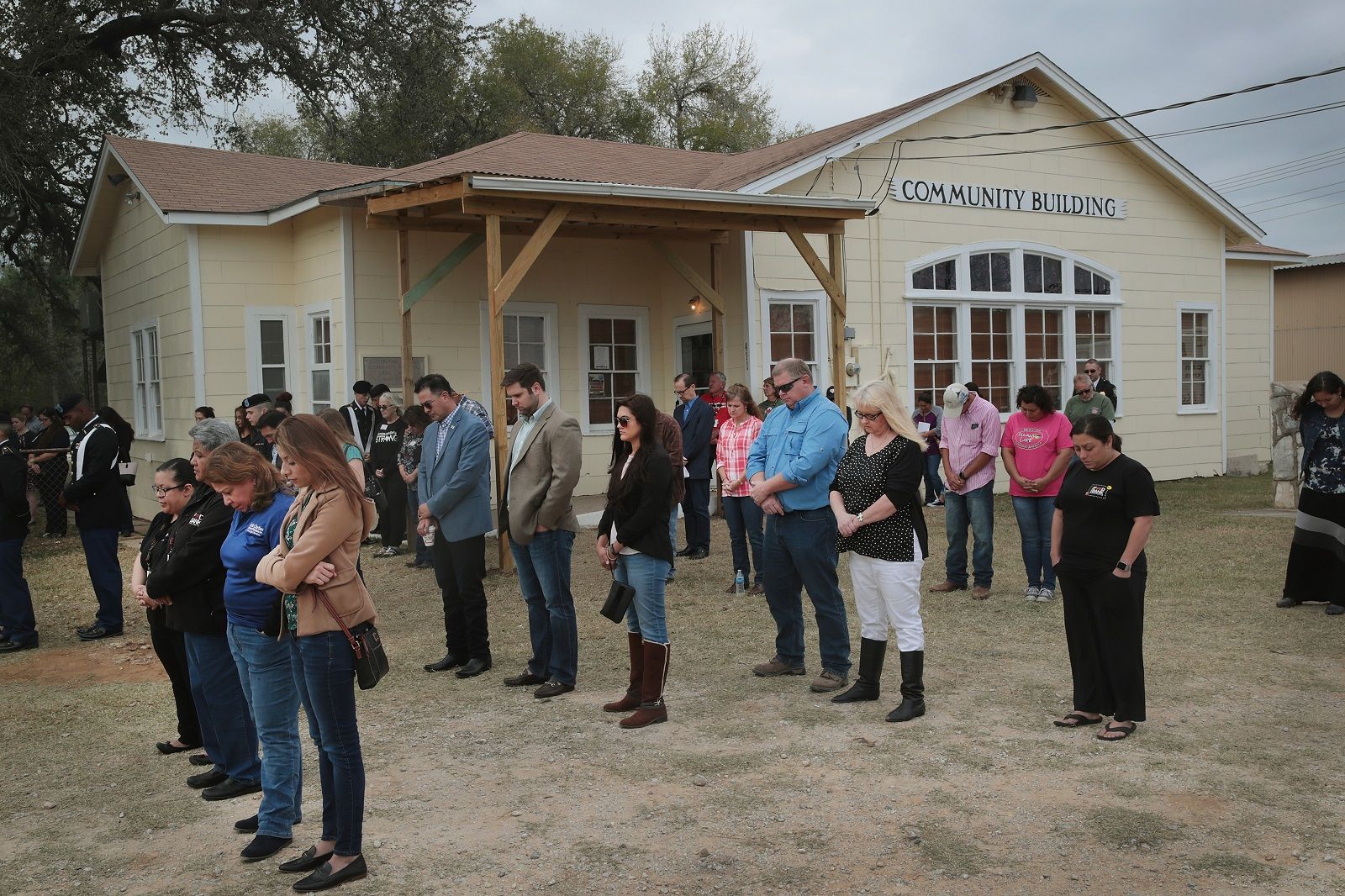 SUTHERLAND SPRINGS, TX - NOVEMBER 11: Residents and visitors share a prayer during a Veterans Day ceremony outside the Community Center on November 11, 2017 in Sutherland Springs, Texas. Residents of the community are still trying to heal following the shooting at the First Baptist Church of Sutherland Springs on November 5. Devin Patrick Kelley shot and killed 26 people and wounded 20 others when he opened fire during Sunday service at the church.  (Photo by Scott Olson/Getty Images)