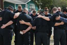 SUTHERLAND SPRINGS, TX - NOVEMBER 11:  First responders share a prayer following a Veterans Day ceremony outside the Community Center on November 11, 2017 in Sutherland Springs, Texas. The men and women were among the first to enter the First Baptist Church of Sutherland Springs to begin treating the wounded following the shooting on November 5. Devin Patrick Kelley shot and killed 26 people and wounded 20 others when he opened fire during Sunday service at the church.  (Photo by Scott Olson/Getty Images)