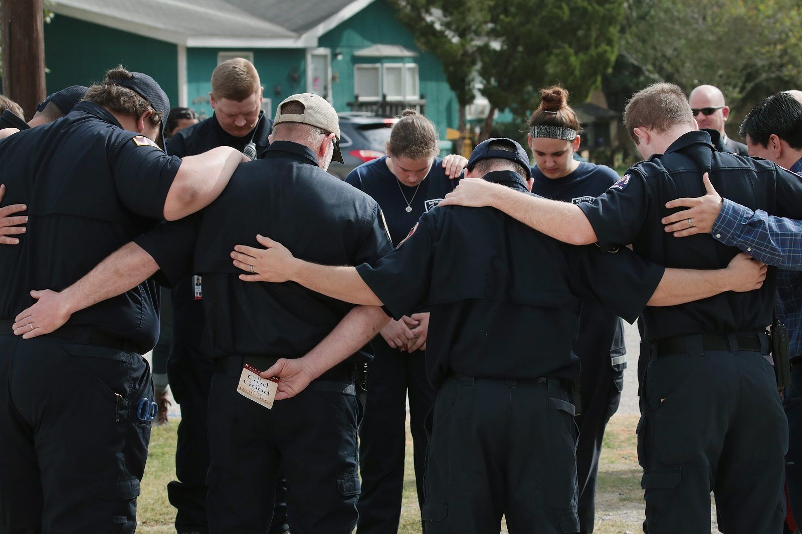 SUTHERLAND SPRINGS, TX - NOVEMBER 11:  First responders share a prayer following a Veterans Day ceremony outside the Community Center on November 11, 2017 in Sutherland Springs, Texas. The men and women were among the first to enter the First Baptist Church of Sutherland Springs to begin treating the wounded following the shooting on November 5. Devin Patrick Kelley shot and killed 26 people and wounded 20 others when he opened fire during Sunday service at the church.  (Photo by Scott Olson/Getty Images)