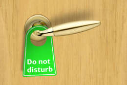 Hotel wood door with a Do not disturb sign