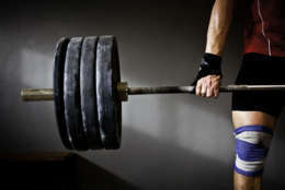 a photo of a man lifting barbell and disks (Thinkstock)