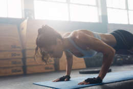 Shot of young woman doing push-ups at the gym. Muscular female doing pushups on exercise mat at gym. Female exercising on fitness mat at gym. (Thinkstock)