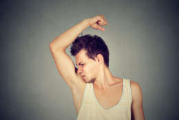 Closeup portrait of young man, smelling, sniffing his armpit, something stinks, very bad, foul odor situation, isolated on gray wall background. Negative emotion, facial expression, feeling. (Thinkstock)