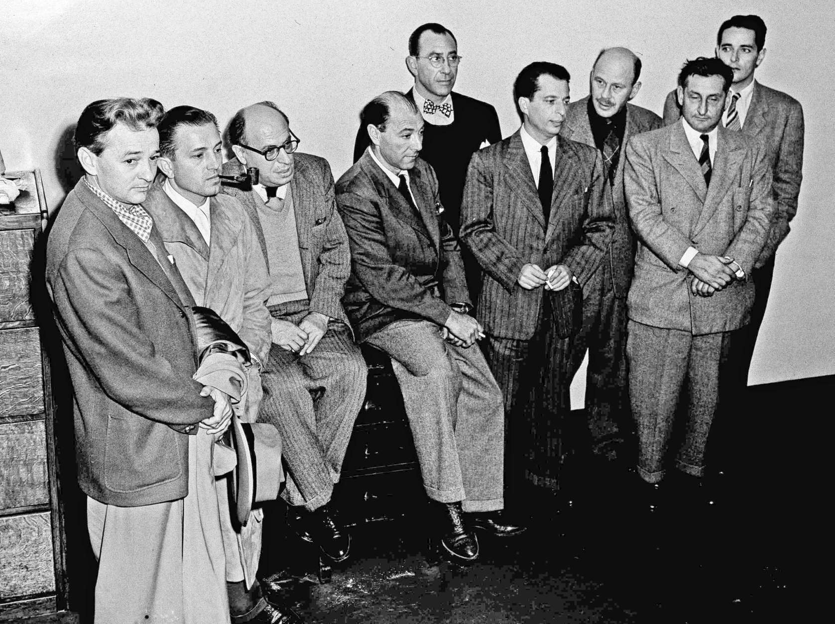 Nine of ten Hollywood writers, directors and producers, indicted by a Washington, D.C., grand jury on charges of contempt of Congress, surrender in a group at the U.S. Marshal's office in Los Angeles, Dec. 10, 1947. From left: Robert Adrian Scott, Edward Dmytryk, Samuel Ornitz, Lester Cole, Herbert Biberman, Albert Maltz, Alvah Bessie, John Howard Lawson and Ring Lardner Jr. The tenth, Dalton Trumbo, sent word he would surrender the following day. (AP Photo/Harold Filan)