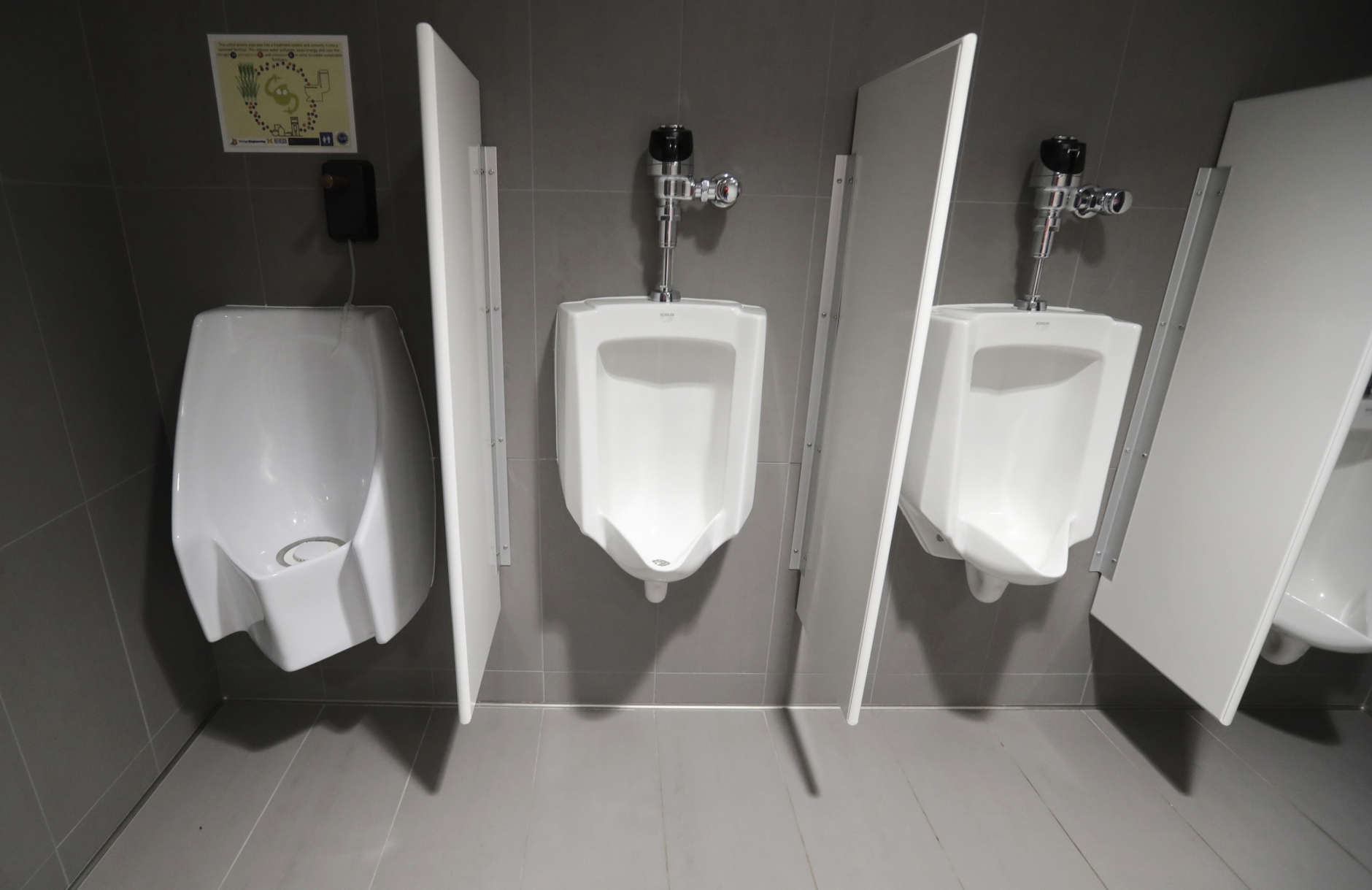 A waterless urinal, left, is shown next to standard urinals at the University of Michigan engineering building, Tuesday, Jan. 24, 2017, in Ann Arbor, Mich. The waterless toilet is connected to a collection and filtration system which is part of a multi-state project researching the conversion of human urine into fertilizer. (AP Photo/Carlos Osorio)