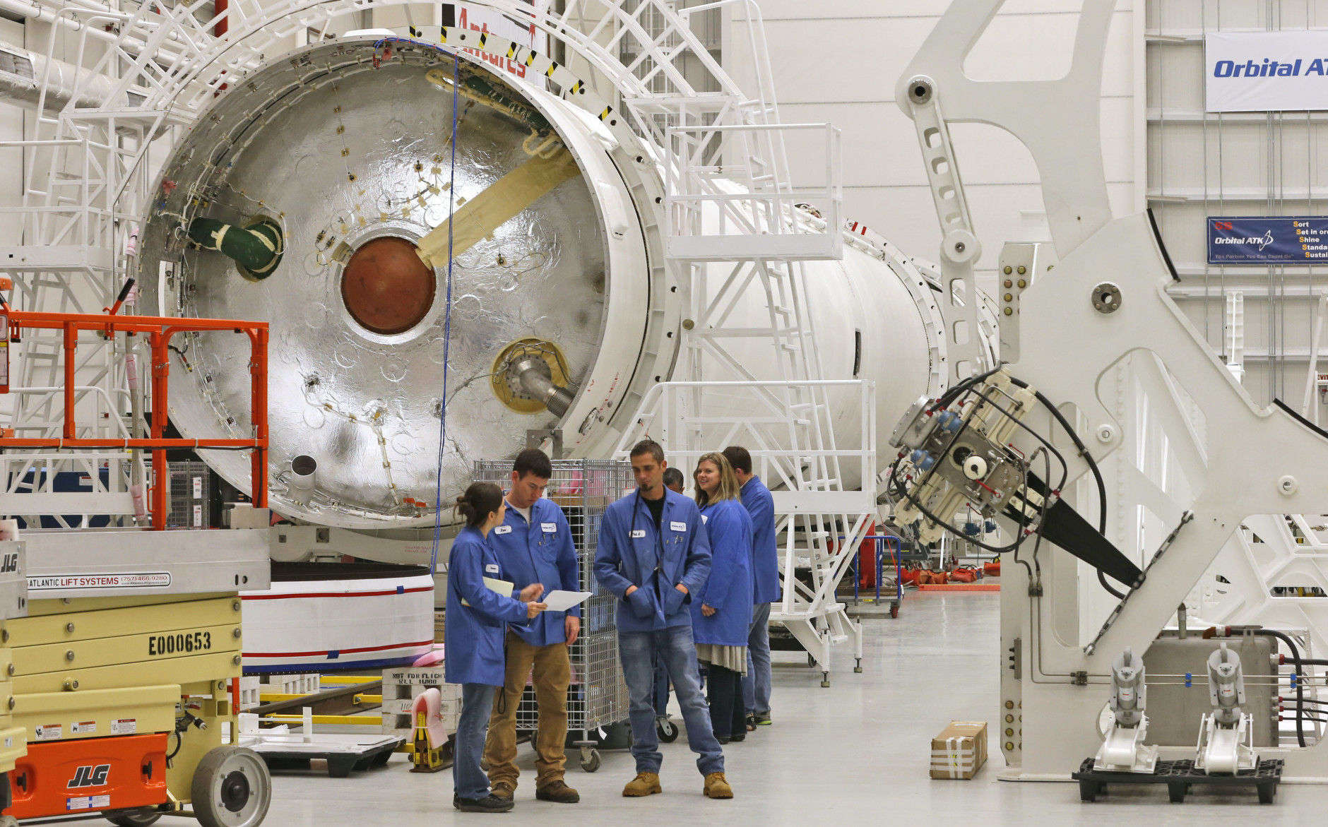 In this Dec. 17, 2015 file photo, workers look over documents in the assembly building for Antares rockets during a tour of the Mid-Atlantic Regional Spaceport at the NASA Wallops Flight Facility on Wallops Island, Va. Orbital ATK turned to the heavens for naming its Antares rocket after the superbright star. (AP Photo/Steve Helber, File)