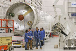 In this Dec. 17, 2015 file photo, workers look over documents in the assembly building for Antares rockets during a tour of the Mid-Atlantic Regional Spaceport at the NASA Wallops Flight Facility on Wallops Island, Va. Orbital ATK turned to the heavens for naming its Antares rocket after the superbright star. (AP Photo/Steve Helber, File)