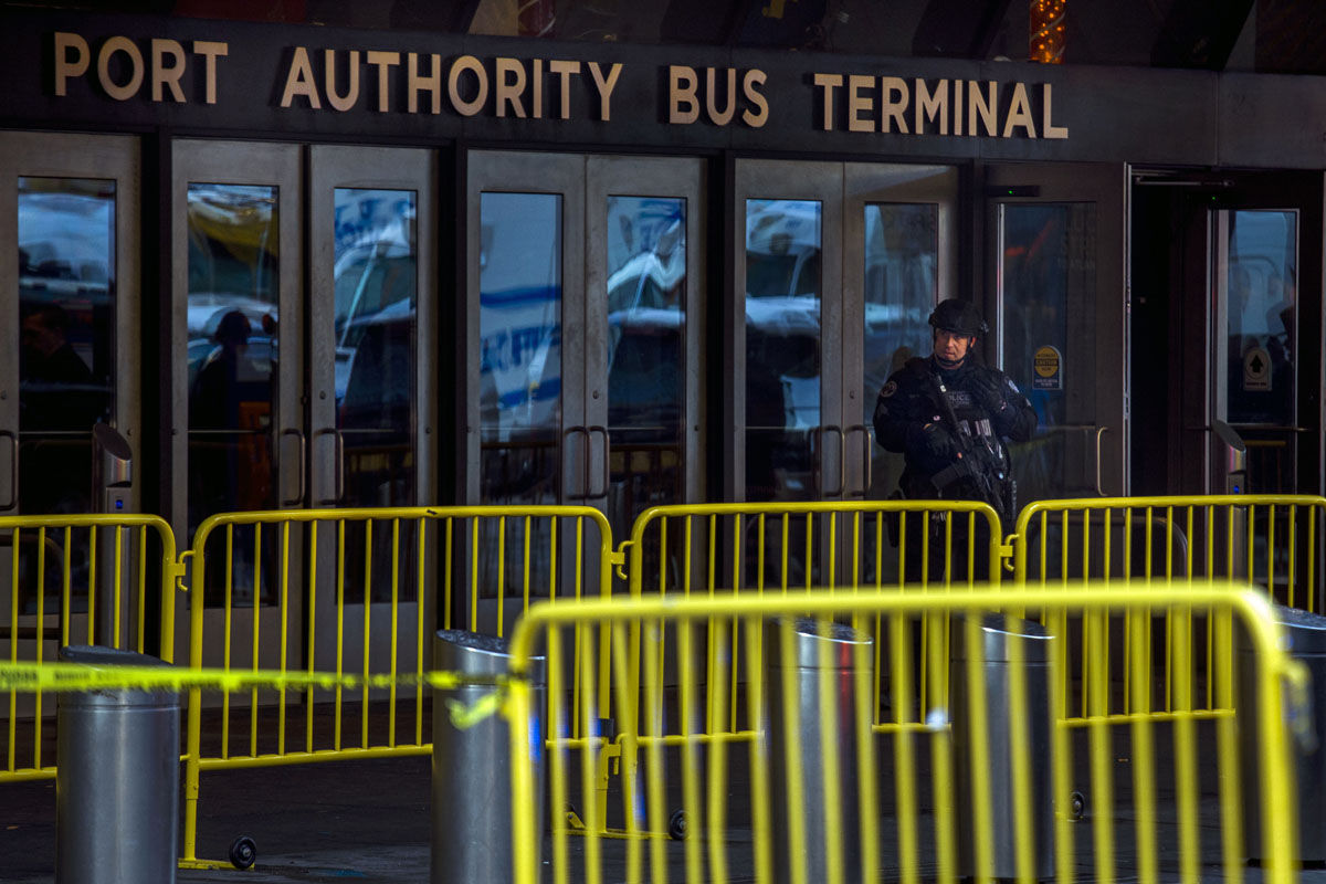 A police officer stands guard in front of Port Authority Bus Terminal as law enforcement respond to a report of an explosion near Times Square on Monday, Dec. 11, 2017, in New York. (AP Photo/Andres Kudacki)