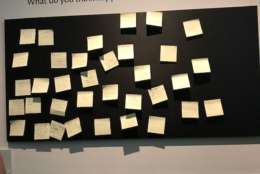 Visitors are encouraged to investigate the Nutshells rather than numbly look on -- and investigate they do. On one wall, a board of post-it notes hang below the question: “What do you think happened in Kitchen Nutshell?” (WTOP/Nahal Amouzadeh)