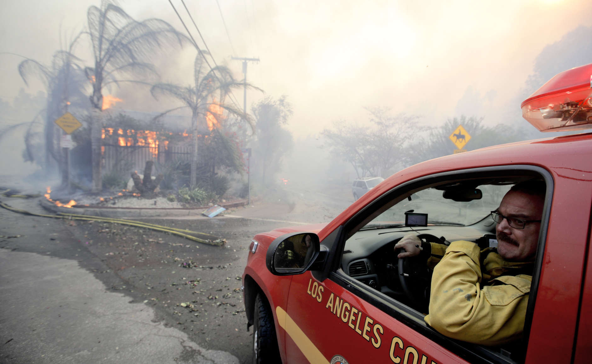 A Los Angeles County firefighter watches as structure burns during the "Creek Fire" in the Lake View Terrace area of Los Angeles, Tuesday, Dec. 5, 2017. (AP Photo/Chris Carlson)