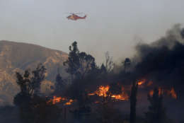 A water dropping helicopter flies over a hot spot on the Creek Fire in the Lake View Terrace area of Los Angeles, Tuesday, Dec. 5, 2017. (AP Photo/Chris Carlson)