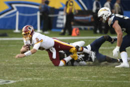 Washington Redskins quarterback Kirk Cousins is hauled down by Los Angeles Chargers defensive end Chris McCain for a sack during the second half of an NFL football game Sunday, Dec. 10, 2017, in Carson, Calif. (AP Photo/Denis Poroy)