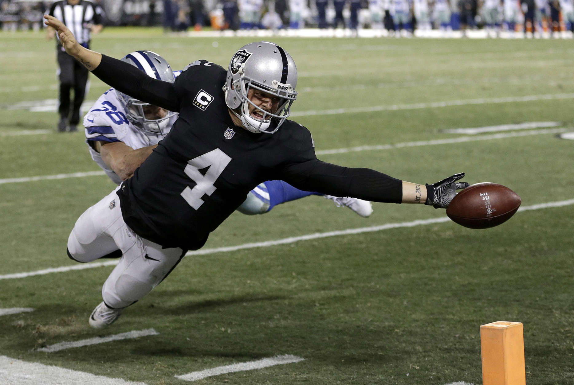 Oakland Raiders quarterback Derek Carr (4) fumbles the ball into the end zone in front of Dallas Cowboys strong safety Jeff Heath (38) during the second half of an NFL football game in Oakland, Calif., Sunday, Dec. 17, 2017. The play was ruled a touchback and the Cowboys got possession. The Cowboys won 20-17. (AP Photo/Ben Margot)