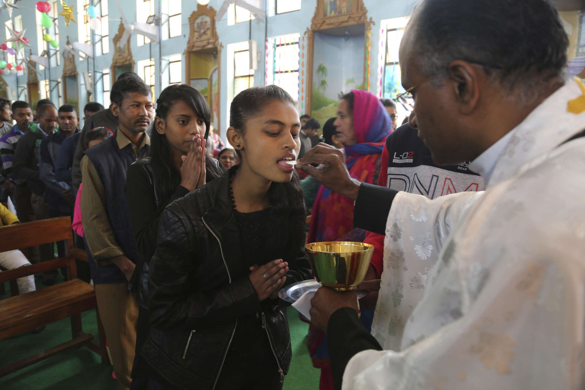 Indian Christians receive communion at Saint Mary's Garrison Church on Christmas Day in Jammu, India, Monday, Dec. 25, 2017. (AP Photo/Channi Anand)