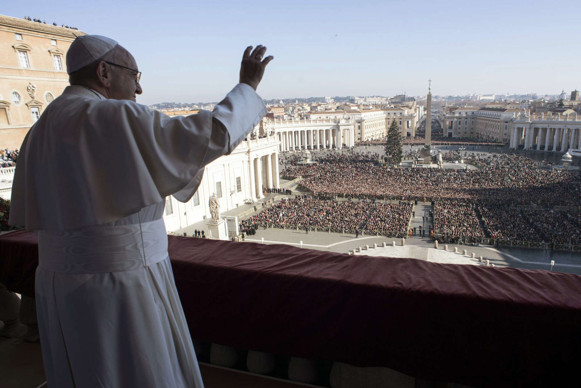 Pope Francis waves to faithful during the Urbi et Orbi (Latin for ' to the city and to the world') Christmas' day blessing from the main balcony of St. Peter's Basilica at the Vatican, Monday, Dec. 25, 2017. (L'Osservatore Romano/Pool Photo Via AP)