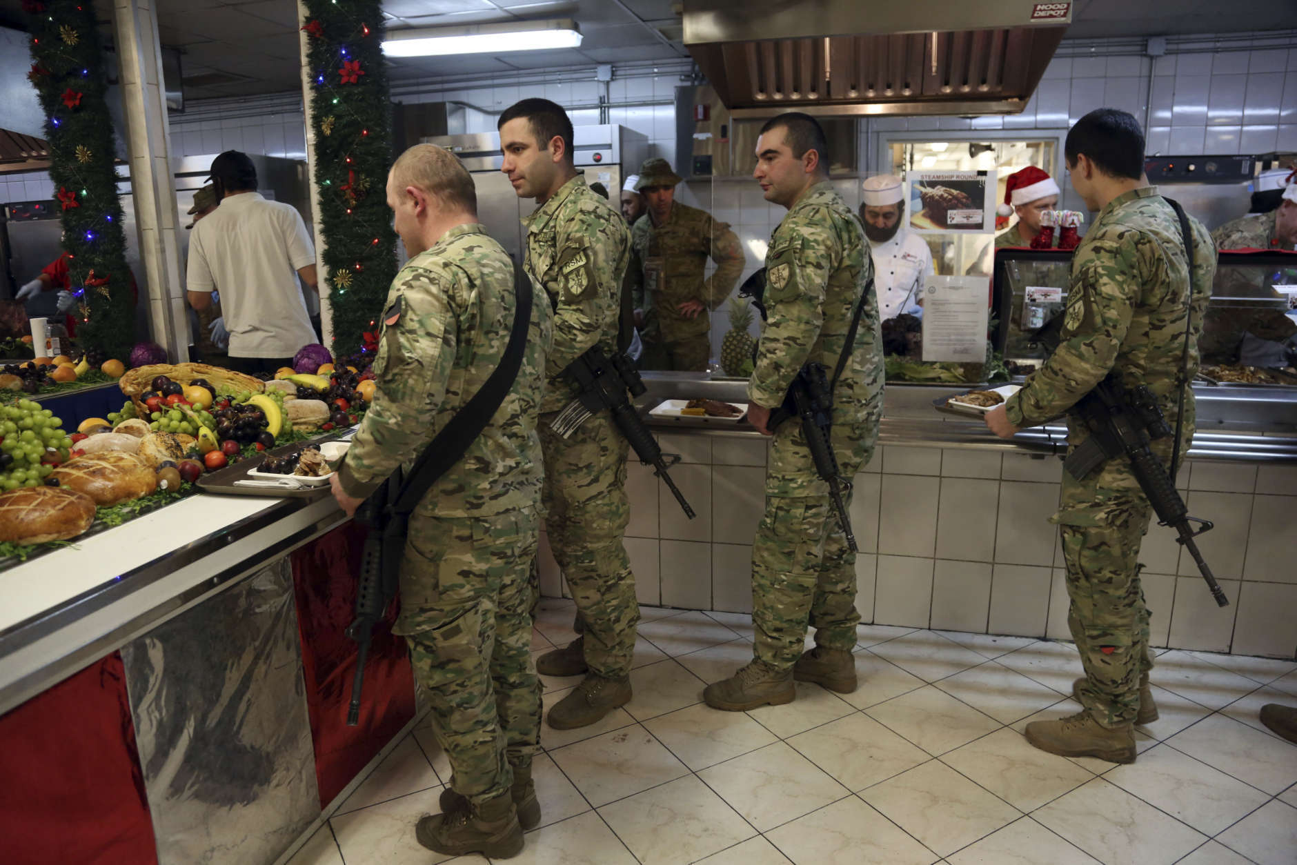 Members of the U.S. military take diner during a ceremony on Christmas Day at the Resolute Support Headquarters in Kabul, Afghanistan, Monday, Dec. 25, 2017. (AP Photo/Rahmat Gul)