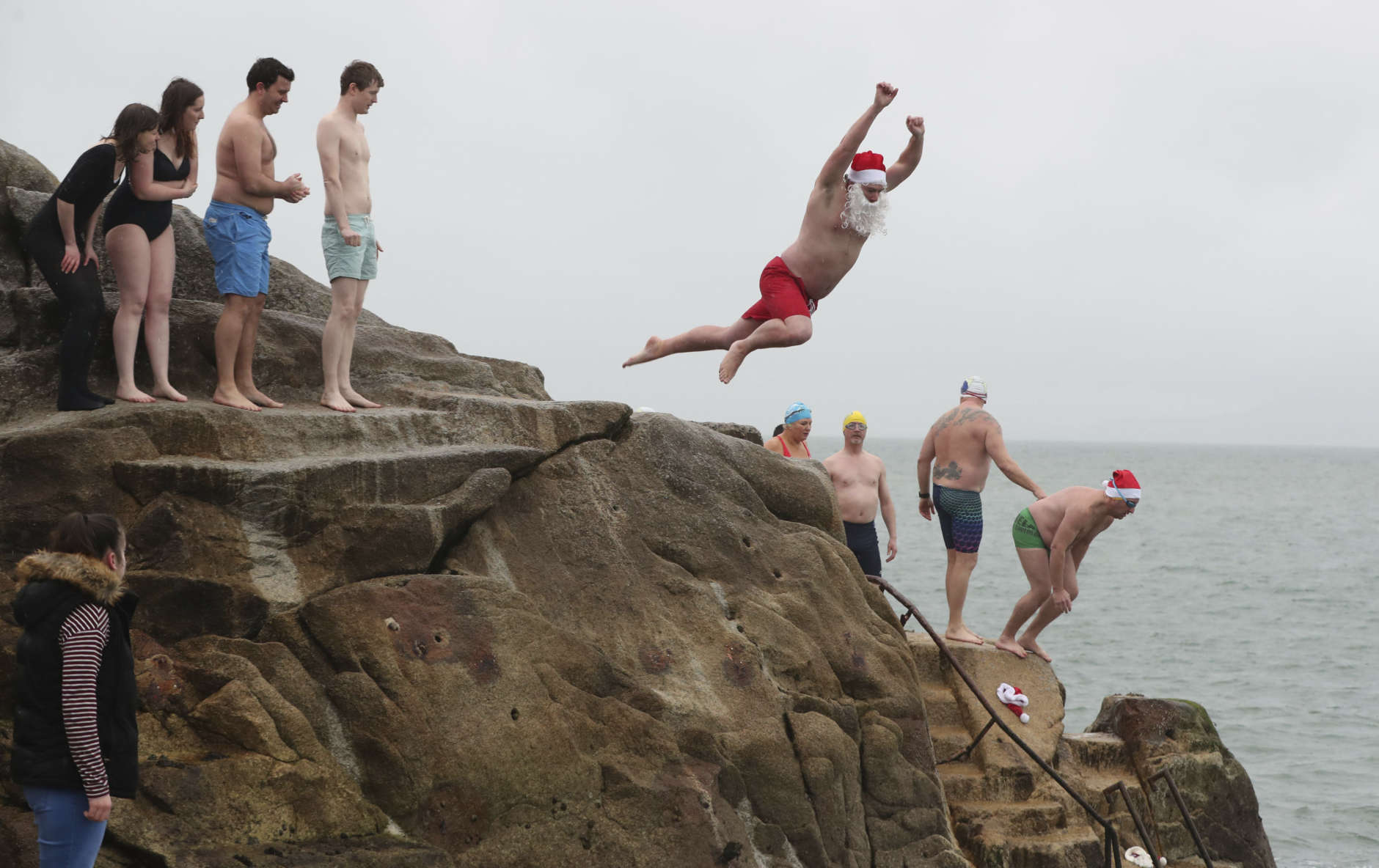 Patrick Corkery, centre, from Castleknock takes part in the annual Christmas Day swim in the Forty Foot, Dun Laoghaire, near Dublin, Ireland, Monday Dec. 25, 2017. (Niall Carson /PA via AP)