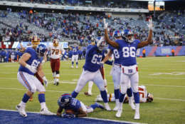 New York Giants' Marquis Bundy (86) and Chad Wheeler (63) check to see if Wayne Gallman (22) scored a touchdown and during the second half of an NFL football game Sunday, Dec. 31, 2017, in East Rutherford, N.J. Gallmann was marked down at the one yard line. (AP Photo/Mark Lennihan)