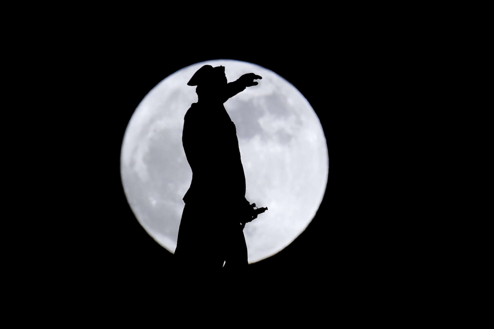 A bronze statue of General George Washington by William Rudolf O'Donovan stands on top of the Trenton Battle Monument while silhouetted by a supermoon, Monday, Jan. 1, 2018, in Trenton, N.J. The monument commemorates the victory at the first Battle of Trenton, which occurred on Dec. 26, 1776, and is located where the artillery dominated the streets of Trenton, preventing the Hessian troops from organizing attacks. Monday's moon is the second of three consecutive supermoons. The first occurred Dec. 3, 2017, and the next will happen on Jan. 31, 2018. (AP Photo/Julio Cortez)