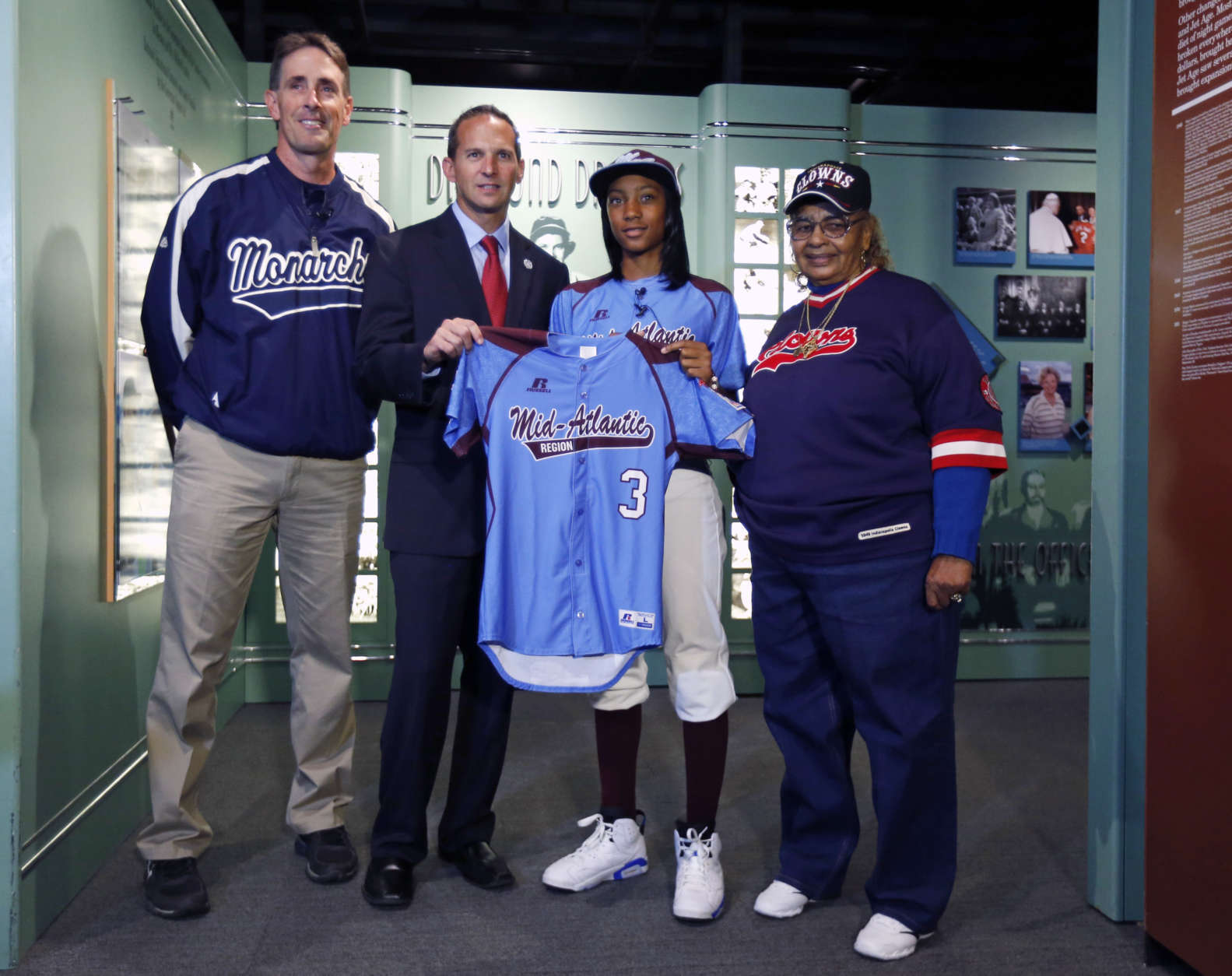 Little League pitcher Mo'ne Davis, second from right, presents the jersey she wore during her shutout win at the Little League World Series to Baseball Hall of Fame President Jeff Idelson  during a ceremony at the hall on Thursday, Sept. 25, 2014, in Cooperstown, N.Y. Also pictured are Steve Bandura, left, who runs the Anderson Monarchs baseball program and Mamie "Peanut" Johnson, who pitched in the Negro Leagues. (AP Photo/Mike Groll)
