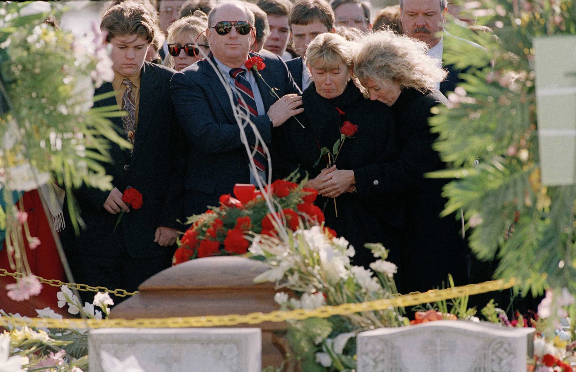 FILE- In this Dec. 13, 1993 file photo, Carolyn McCarthy, center, stands by the casket of her slain husband Dennis McCarthy at Holy Road Cemetery in Westbury, N.Y., Dec. 13, 1993. Mr. McCarthy was shot to death aboard a Long Island Railroad commuter train and their son, Kevin, was critically injured as well. In what was at the time one of the worst mass killings in history, a deranged gunman opened fire aboard a Long Island Rail Road train filled with commuters leaving New York City. Six people died and 19 were injured.  (AP Photo/Mike Albans, File)