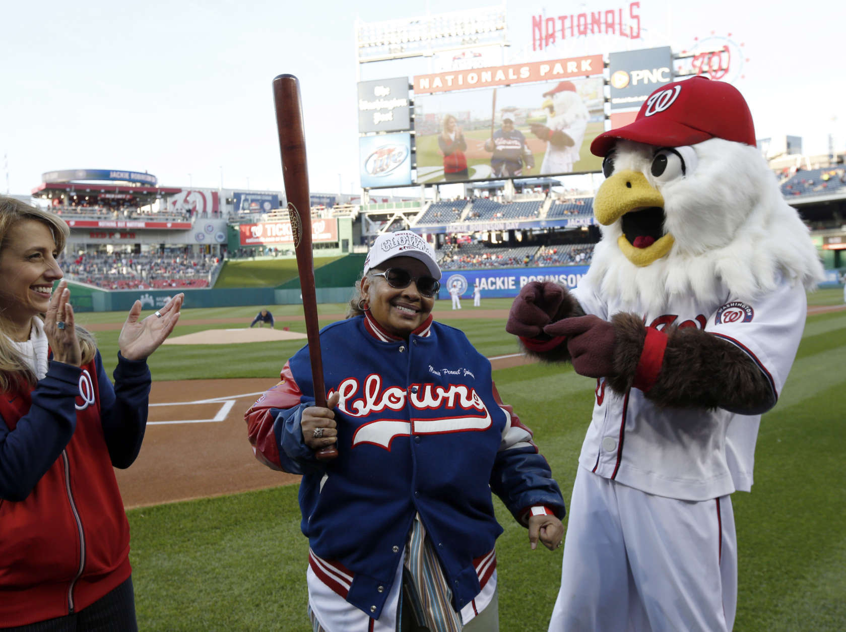 Mamie "Peanut" Johnson, center, holds a bat she was presented as she is honored on before a baseball game between the Washington Nationals and the St. Louis Cardinals at Nationals Park Thursday, April 17, 2014, in Washington. Johnson was one of three women to play in the Negro Leagues. (AP Photo/Alex Brandon)