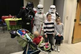 Three Star Wars bad guys pose with three kids, including one who can’t stop staring. (WTOP/Michelle Basch)