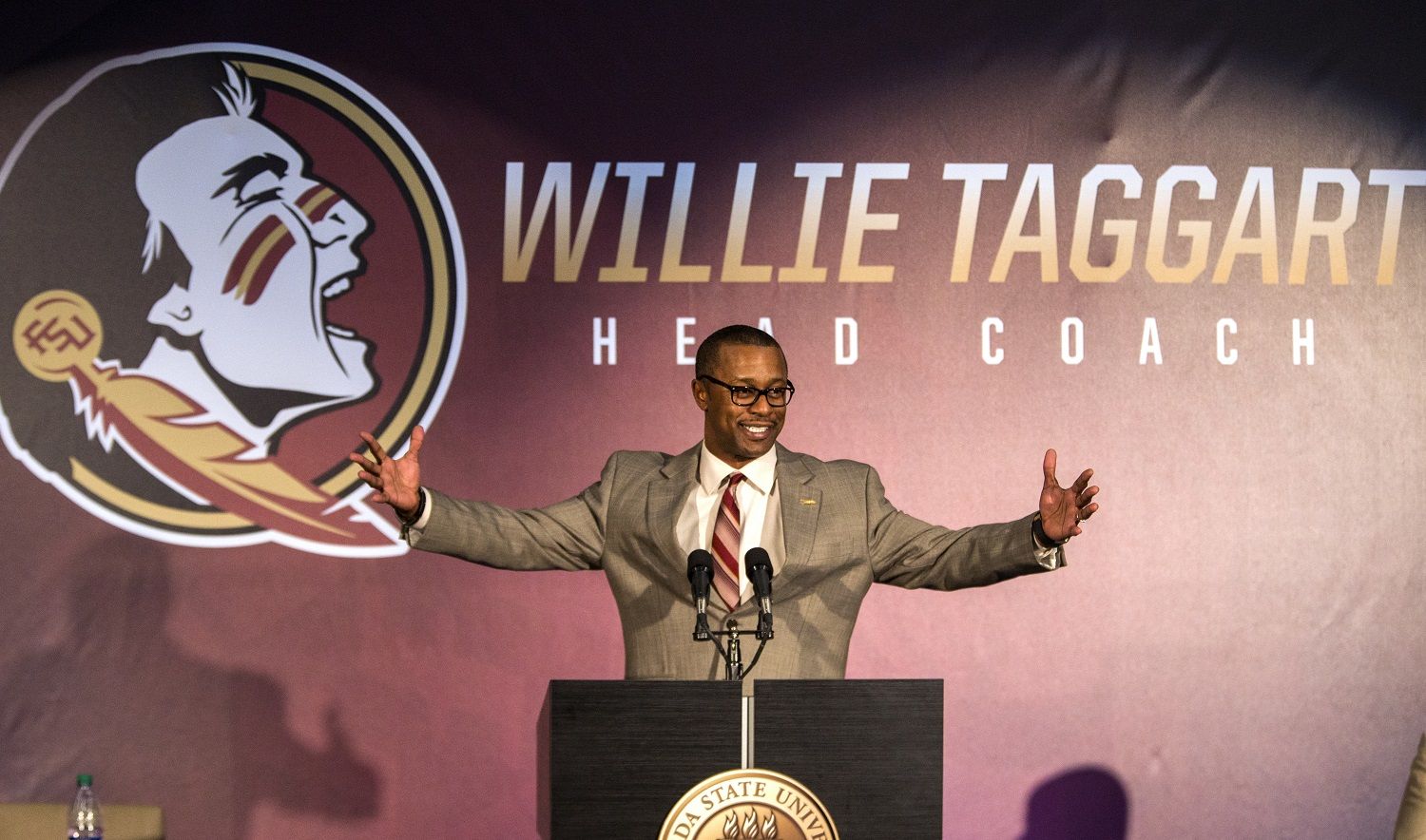 FILE - In this Dec. 6, 2017, file photo, Willie Taggart gestures as he is introduced as Florida State's new football coach during an NCAA college football news conference in Tallahassee, Fla. A potential new tax on seven-figure salaries for employees of non-profits hasn’t deterred schools from doling out huge contracts to new coaches. (AP Photo/Mark Wallheiser, File)