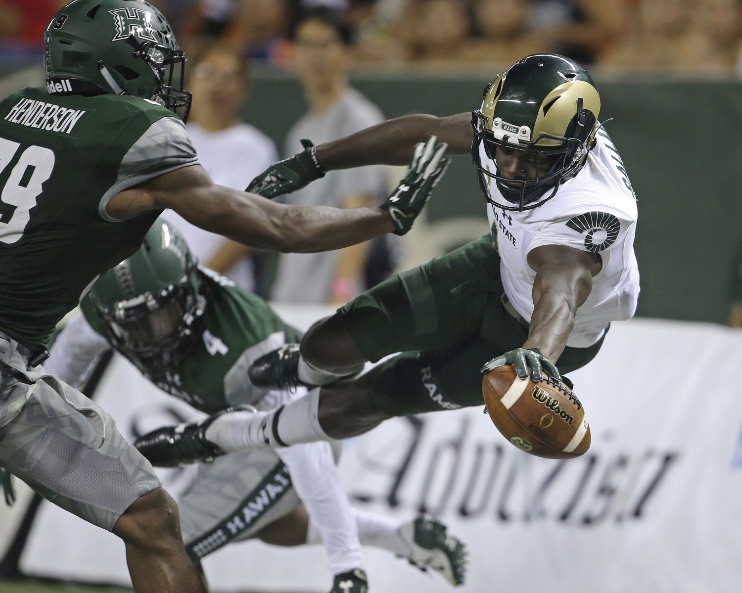 While guarded by Hawaii defensive backs Trayvon Henderson (39) and Daniel Lewis Jr. (4), Colorado State wide receiver Michael Gallup (4) tries to leap into the end zone but stepped out of bounds during the second quarter of the NCAA college football game against Hawaii, Saturday, Sept. 30, 2017, in Honolulu. (AP Photo/Marco Garcia)