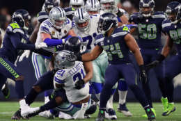ARLINGTON, TX - DECEMBER 24:  Ezekiel Elliott #21 of the Dallas Cowboys is tackled in the first half of a football game against the Seattle Seahawks at AT&amp;T Stadium on December 24, 2017 in Arlington, Texas.  (Photo by Tom Pennington/Getty Images)