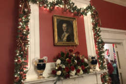 Fresh garland hung over doorways and framed the painting of George Washington by Charles Wison Peale, which hangs above one of the fireplaces in the drawing room. (WTOP/Dick Uliano)