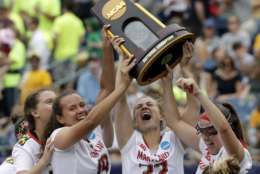 Maryland's Alex McKay (19), Bairre Reilly (32) and Meghan Doherty, far right, celebrate with the trophy after they defeated Boston College to win the NCAA college Division 1 lacrosse championship final, Sunday, May 28, 2017, in Foxborough, Mass. (AP Photo/Elise Amendola)