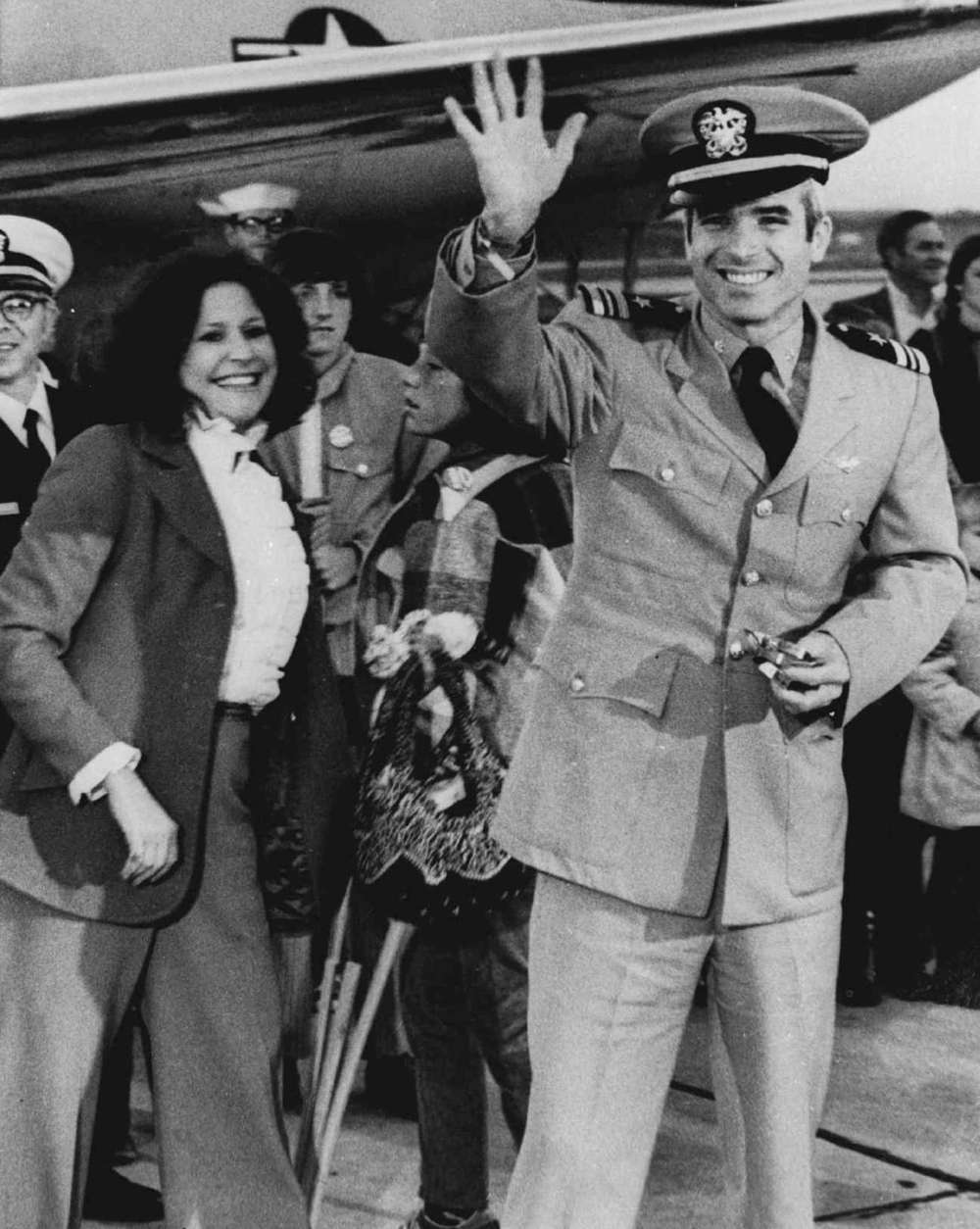 Lt. Commander John S. McCain III, a POW for over five years, waves to well wishers March 18, 1973 after arriving at Jacksonville Naval Air Station in Florida.  At left is his wife, and son Doug, who is on crutches after breaking his leg in a soccer game. McCain is the son of Adm. John S. McCain Jr, who commanded the U.S. Forces in the Pacific until his retirement. (AP Photo)