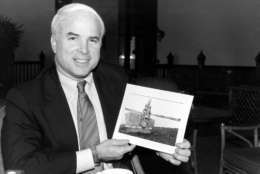 U.S. Rep. John McCain III, R-Ariz., holds a photo of a marker in Hanoi at Truc Bach Lake where he parachuted after being shot down as a Navy pilot in the Vietnam War.  McCain, who was a POW for five and one half years in Hanoi, is in Bangkok, Thailand, on Feb. 18, 1985 en route to Hanoi to visit this site.  (AP Photo/Jim Bourdier)
