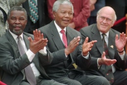 FILE - In this May 8, 1996 file photo, South African President Nelson Mandela, center, applauds along with his two deputy presidents, Thabo Mbeki, left, and F.W. de Klerk, after a new constitution was approved by the Constitutional Assembly in Cape Town, South Africa.   South Africa's president Jacob Zuma says, Thursday, Dec. 5, 2013, that Mandela has died. He was 95.  (AP Photo/Argus, Leon Muller, File)
