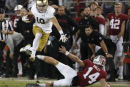 Notre Dame's Chris Finke (10) leaps over Stanford punter Jake Bailey (14) on a punt return during the second half of an NCAA college football game Saturday, Nov. 25, 2017, in Stanford, Calif. Stanford won 38-20. (AP Photo/Tony Avelar)