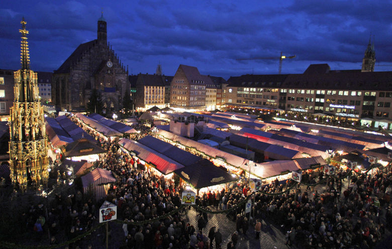 People crowd around the stalls in front of the church of Our Lady and the Gothic fountain, left, during the opening of the world renown Christmas market in Nuremberg, southern Germany, Friday, Nov. 27, 2009. (AP Photo/Matthias Schrader)