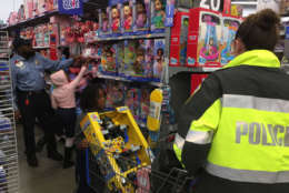 D.C. Police Officer Samuel Gaines helps Makayah reach for a toy.
 (WTOP/Kristi King)