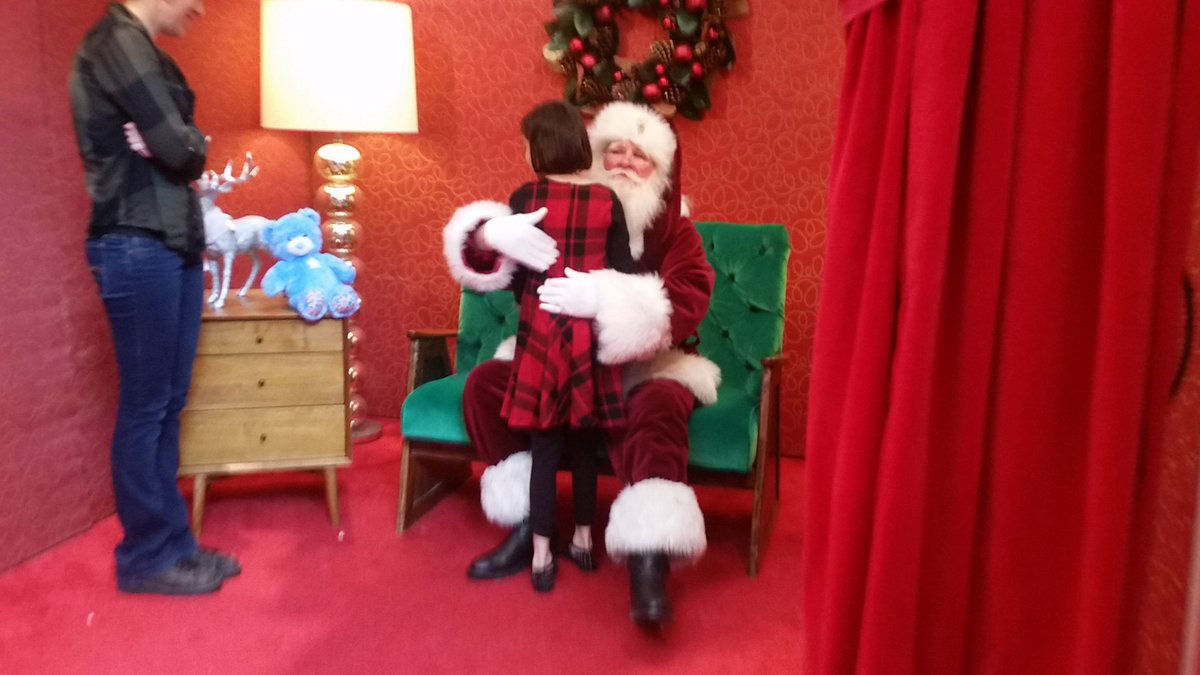 Kaylee Lyons gives Santa a hug at inaugural sensory friendly Santa event at Springfield Town Center. Similar events taking place at 375 locations across the U.S. Provides calmer environment, no crowds, no loud noises and no bright lights for children with sensory issues. (WTOP/Kathy Stewart)