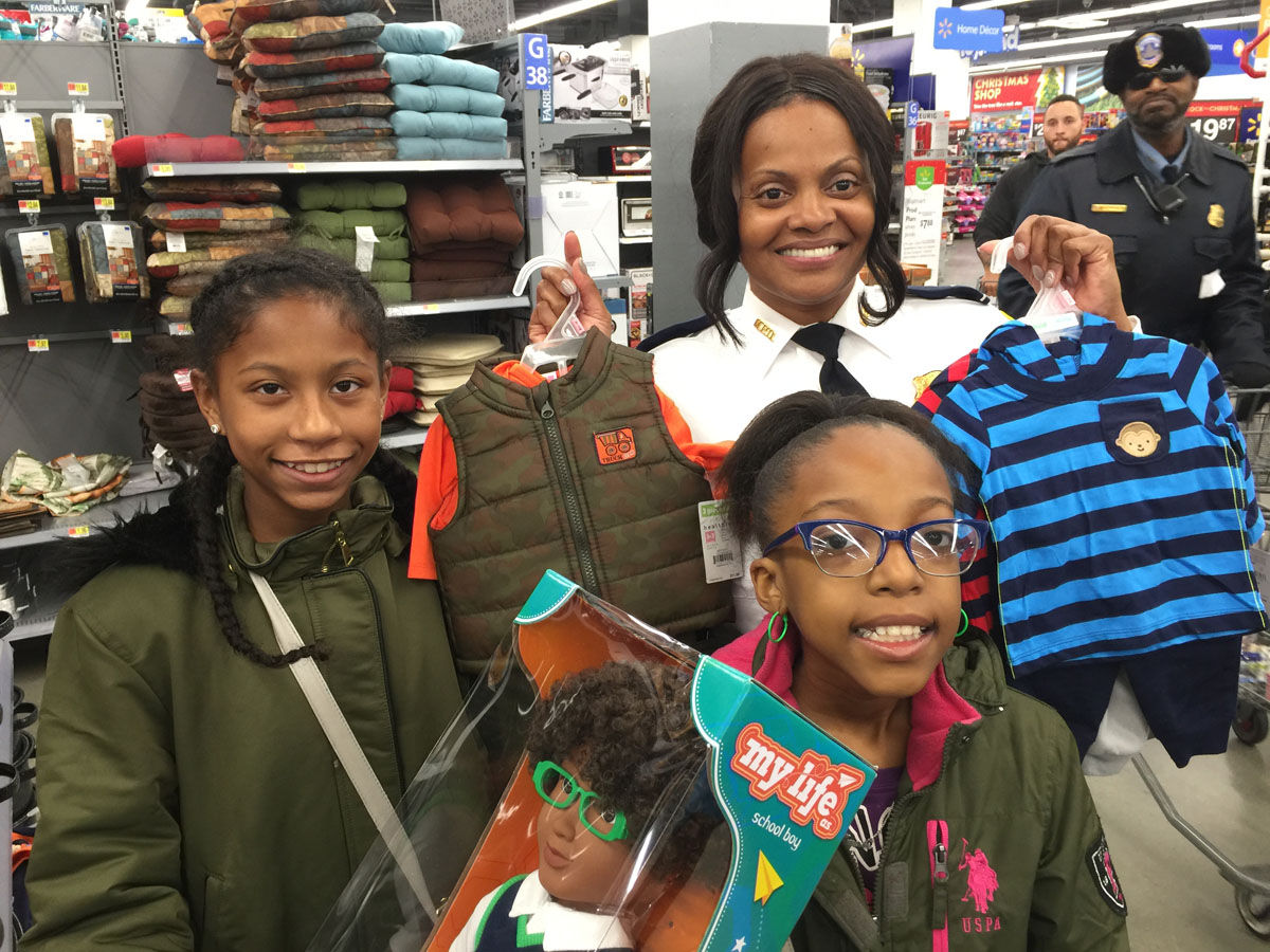 Indie, 11, and her cousin Kyah, 10, shop with D.C. Police Commander Chanel Dickerson on Wednesday, Dec. 6, 2017. (WTOP/Kristi King)