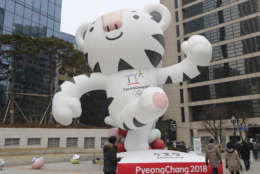 People walk by an official mascot of the 2018 Pyeongchang Olympic Winter Games, white tiger "Soohorang" in downtown Seoul, South Korea, Friday, Dec. 29, 2017. South Korea's Pyeongchang is the host city of the 2018 Olympic and Paralympic Winter Games which will be held from February 2018. (AP Photo/Lee Jin-man)