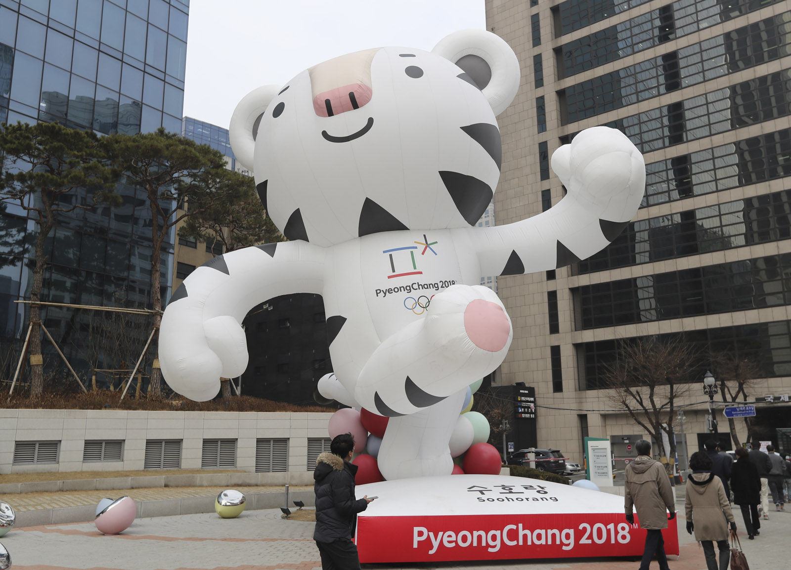 People walk by an official mascot of the 2018 Pyeongchang Olympic Winter Games, white tiger "Soohorang" in downtown Seoul, South Korea, Friday, Dec. 29, 2017. South Korea's Pyeongchang is the host city of the 2018 Olympic and Paralympic Winter Games which will be held from February 2018. (AP Photo/Lee Jin-man)