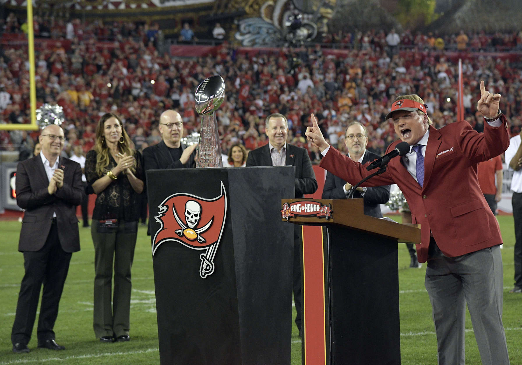 Former Tampa Bay Buccaneers Jon Gruden, far right, raises his arms to the fans as he is inducted into the teams Ring of Honor during halftime at an NFL football game between the Tampa Bay Buccaneers and the Atlanta Falcons, Monday, Dec. 18, 2017, in Tampa, Fla. (AP Photo/Phelan M. Ebenhack)
